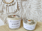 Vela aromatica de soja con piedras y plantas naturales
