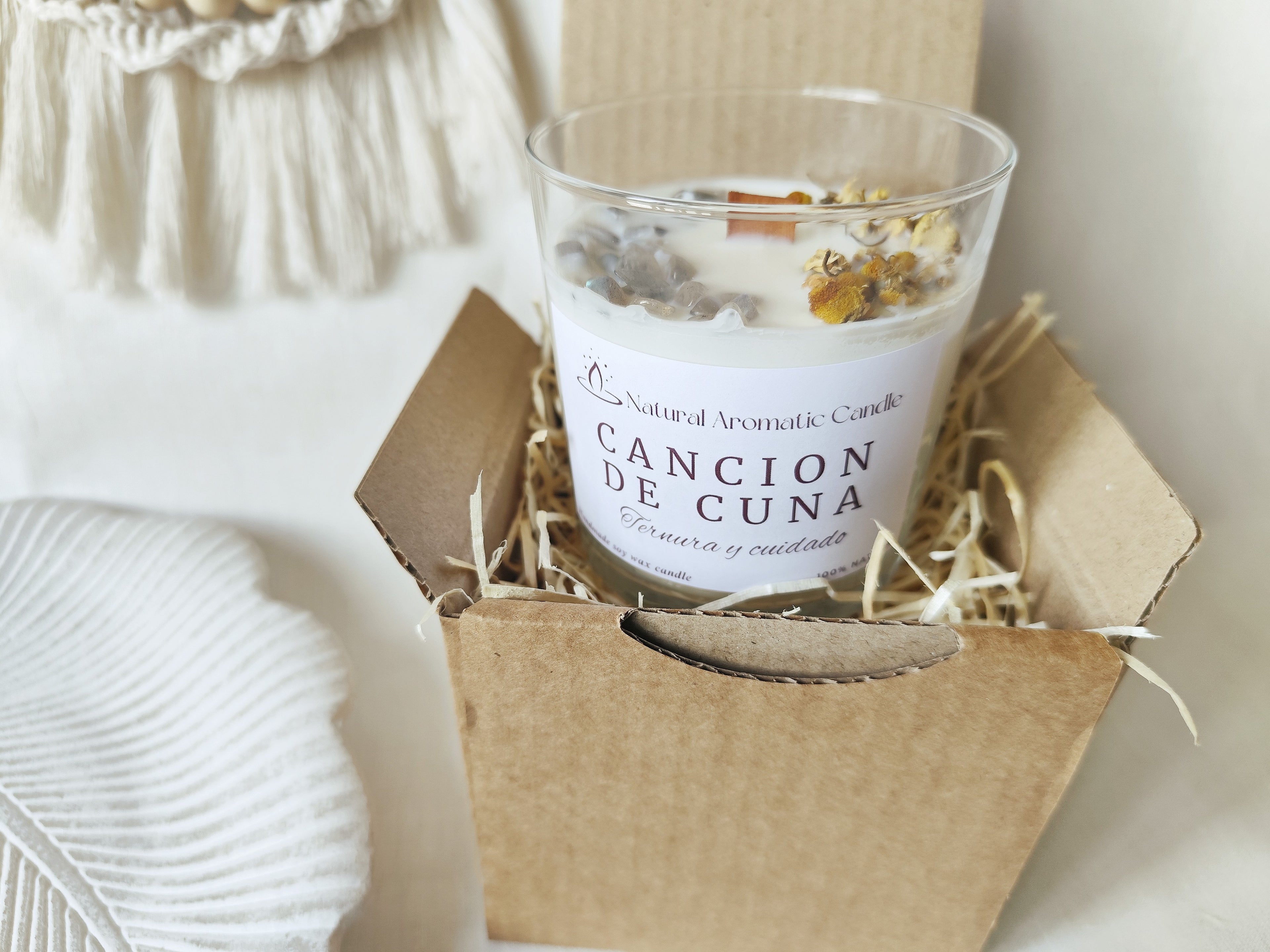 Vela Canción de Cuna con flores de manzanilla y piedra luna en un diseño delicado y acogedor.