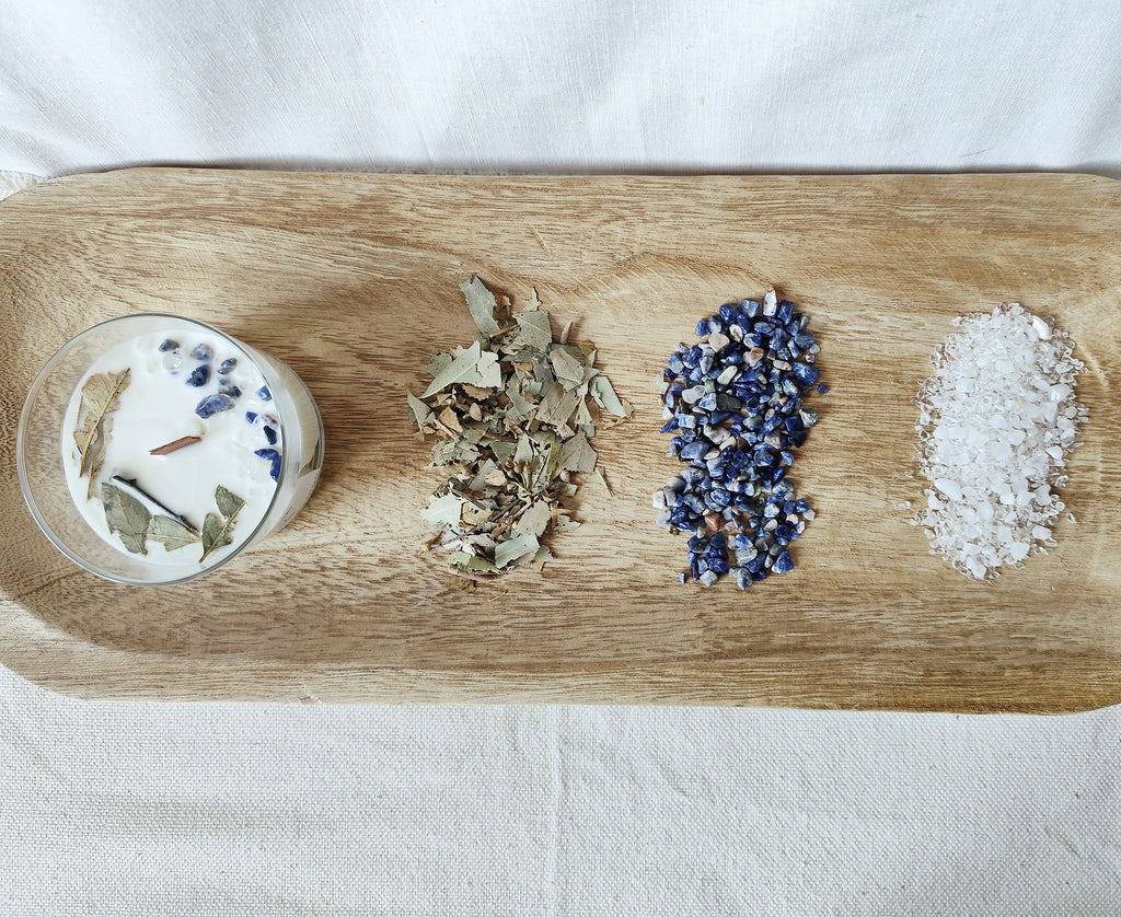 Vela de soja en bandeja de madera con piedras naturales y plantas naturales